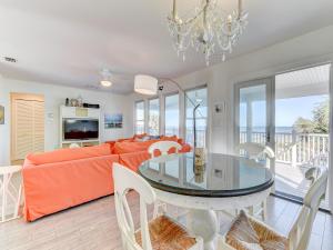 - un salon avec un canapé orange et une table en verre dans l'établissement Four Palms, 4 Bedrooms, Sleeps 10, WiFi, Ocean Front, à Saint Augustine