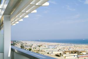 Blick auf den Strand vom Balkon eines Gebäudes in der Unterkunft Club House Hotel in Rimini