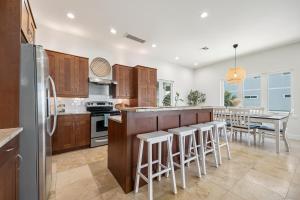 a kitchen with wooden cabinets and a table with bar stools at Endless Views, 4 Bedrooms, Wi-Fi, Ocean View, Private Pool, Sleeps 12 in Saint Augustine