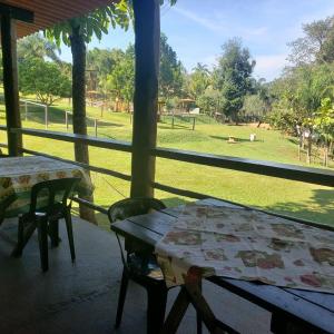 圣代佩德罗Cabana Hostel Sobrado EcoPark的门廊上的桌椅,享有公园的景致