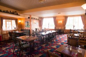 um restaurante com mesas e cadeiras num quarto em The Highwayman Inn em Shepton Mallet