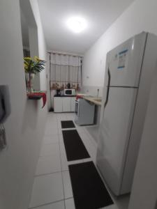 a kitchen with white appliances and a refrigerator at Apto 1 Agua Marinha in Campos dos Goytacazes +5 photos