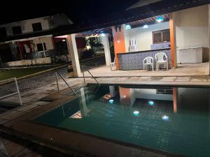 uma piscina em frente a uma casa à noite em CASA DUPLEX em CONDOMÍNIO à beira do RIO PREGUIÇAS em Barreirinhas