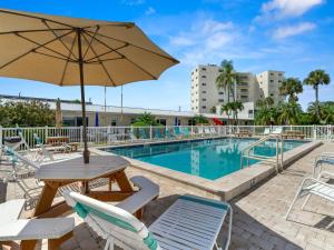 un tavolo con ombrellone accanto alla piscina di Jamaica Royale 101, 2 Bedrooms, 3 Heated Pools, WiFi, Sleeps 6 a Siesta Key