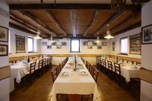una grande sala da pranzo con tavoli e sedie in esso di Agriturismo Cornolade a Ponte nellʼAlpi