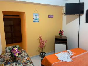 um quarto com uma cama, uma mesa e uma televisão em Pousada 461 em Recife