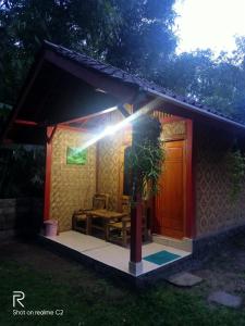 a small house with a table and a light on it at Tereng Wilis Jungle Inn in Tetebatu