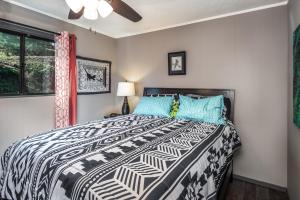 Un dormitorio con una cama con un edredón blanco y negro. en Valley View, en Ruidoso
