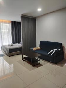 a living room with a couch and a bed at Urban360 Pool view stylist with android Tv in Batu Caves