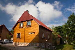 a small wooden house with a red roof at Apartments Peaks in Žabljak