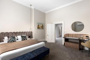 a bedroom with a bed and a desk and a mirror at Mount Gambier Hotel in Mount Gambier