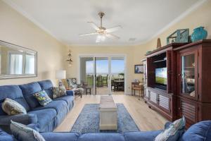 sala de estar con sofá azul y TV en 442 Cinnamon Beach, 3 Bedroom, Sleeps 8, Ocean View, 2 Pools, Pet Friendly, en Palm Coast