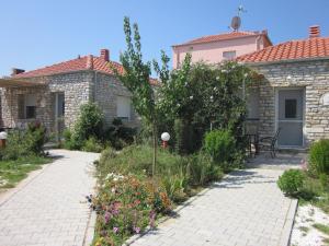 a garden in front of a house with flowers at Petra Houses in Potos