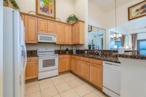 a kitchen with wooden cabinets and white appliances at 862 Cinnamon Beach, 3 Bedroom, Sleeps 8, Ocean Front, 2 Pools, Pet Friendly in Palm Coast