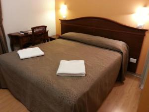 1 dormitorio con 1 cama con 2 toallas en Guesthouse Alex II, en Roma