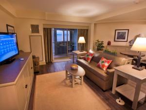 a living room with a couch and a television at 1000 Islands Harbor Hotel in Clayton