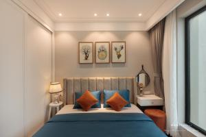 una camera da letto con un letto con cuscini blu e arancioni di Căn hộ cao cấp 2 phòng ngủ Altara Quy Nhơn tầng cao, view biển - MARIS Condotel a Quy Nhon