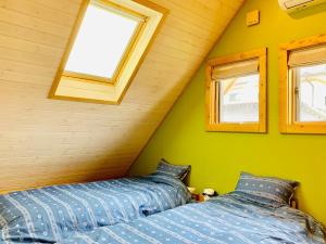 two beds in a room with green walls and windows at TanTei / Vacation STAY 5504 in Yachimata