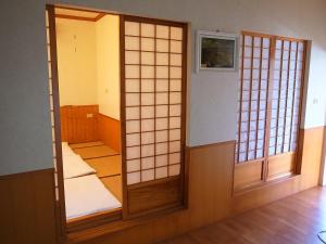 a room with a pair of japanese doors at The LianFamily Teahouse B&B台東民宿001號 in Yongan