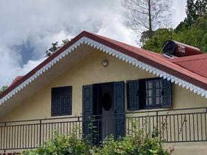 una casa con techo rojo y ventanas negras en Chalet DIKA en Cilaos