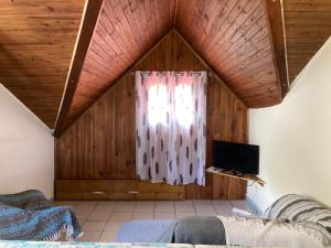 una camera da letto con soffitto in legno e finestra di Chalet DIKA a Cilaos