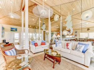 a living room with white furniture and a wooden ceiling at Ocean Pearl in Saint Augustine