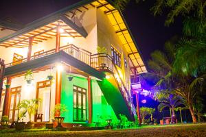 a house with a lit up facade at night at Lavender Home Yala Safari in Tissamaharama