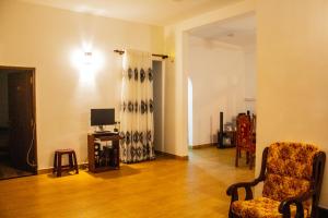 a living room with a chair and a television at Lavender Home Yala Safari in Tissamaharama