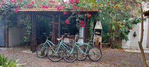 cuatro bicicletas estacionadas frente a un edificio con flores en Casa Alma Zen - Hostel Boutique & Bistrô Ubatuba, en Ubatuba