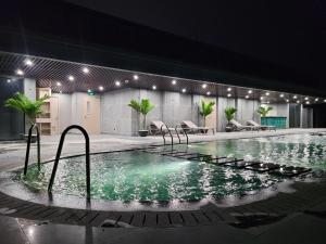 a swimming pool at night with chairs and lights at Căn hộ cao cấp 2 phòng ngủ Altara Quy Nhơn tầng cao, view biển - MARIS Condotel in Quy Nhon