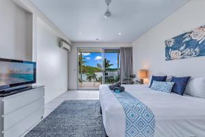 a bedroom with a bed and a flat screen tv at Baybliss Apartments 1 Bedroom WiFi in Shute Harbour