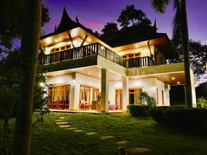 una casa grande de noche con las luces encendidas en Tropical garden, en Phuket