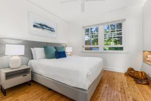 a bedroom with a large bed and two windows at Mulwarree Avenue Apartments by Urban Rest in Sydney