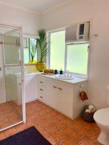 een badkamer met een wastafel, een toilet en een raam bij Garreembee 1770 House in Seventeen Seventy