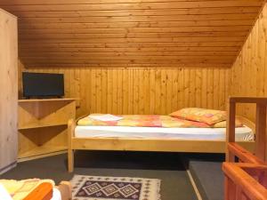 um pequeno quarto com uma cama num quarto de madeira em Manó Kulcsosházak em Praid