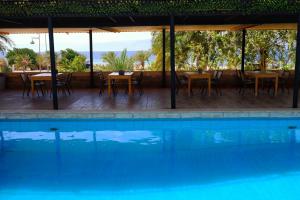 a swimming pool with a table and chairs and a table and a swimming pool at Darna Divers Village in Aqaba