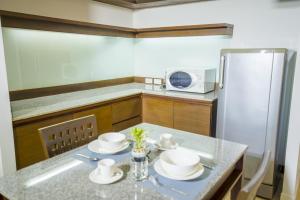 a kitchen with a table and a refrigerator at Sitara Place Serviced Apartment & Hotel in Bangkok