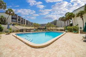 - une piscine dans une cour avec un bâtiment et des palmiers dans l'établissement Island View, 2 Bedrooms, Sleeps 8, Ocean Front, Pool, Tennis, WiFi, à Saint Augustine