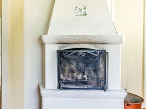 una chimenea blanca en una esquina de una habitación en Holiday home FLEN III, en Flen