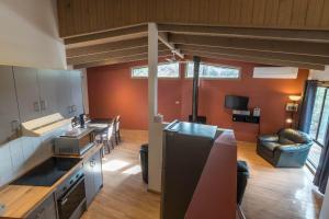 a kitchen and living room with red walls at Wonderland Cottages in Halls Gap