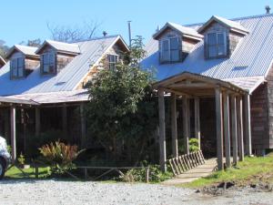 uma casa com um telhado de metal em cima em Hosteria Catalina sm em Hornopirén