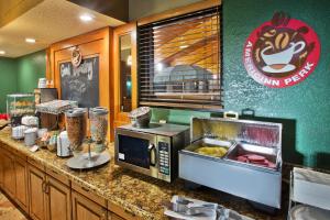 cocina con encimera y microondas en AmericInn by Wyndham Lincoln North en Lincoln