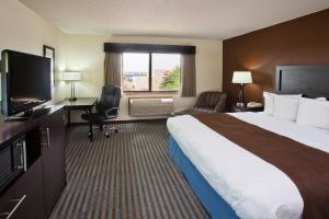 a hotel room with a large bed and a flat screen tv at AmericInn by Wyndham Lincoln North in Lincoln