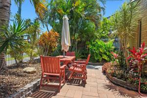 Motel Sunshine Coast في كالوندرا: طاولة مع كرسيين ومظلة