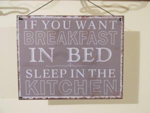 un cartel que dice que si quieres desayunar en la cama duerme en la cocina en Cascina Antonini, en Foligno