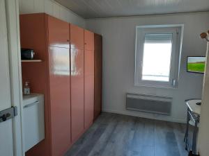 a kitchen with orange cabinets and a window at Le pigeonnier 1 in Le Tréport +2 photos