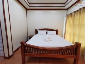 un dormitorio con una cama con un animal de peluche en Sand-D House Pool Villa A15 at Rock Garden Beach Resort Rayong, en Mae Pim