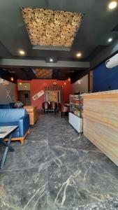 a lobby with a blue couch and tables and chairs at Hotel Ventures Inn in Amritsar