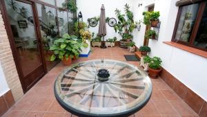 un patio con una rueda de agua en un patio con macetas en CASA RURAL QUIJOTE Y SANCHO en Argamasilla de Alba