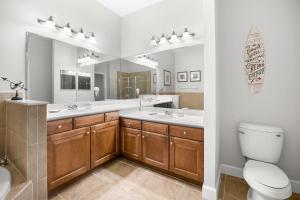 a bathroom with two sinks and a toilet and a mirror at 832 Cinnamon Beach in Palm Coast